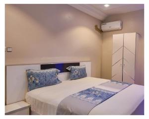 Un dormitorio con una cama con almohadas azules y blancas. en Hotel Residence Ami Bamba, en Sali Nianiaral 22 fotos más