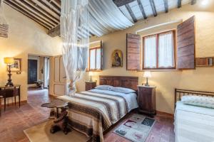a bedroom with a bed and a desk and windows at Antiche Dimore Del Vescovado in Murlo +102 photos
