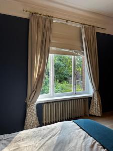 a bedroom with a window with curtains and a bed at La villa Chatorya in Spa