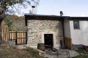 a stone house with a table and chairs in front of it at la stalla di mario in Perondo