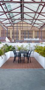 a patio with a black table and two chairs at The companions house in Sathani Bang Su