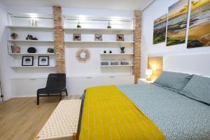 a bedroom with a yellow bed and a black chair at Calderón de la Barca By Cuencaloft in Cuenca
