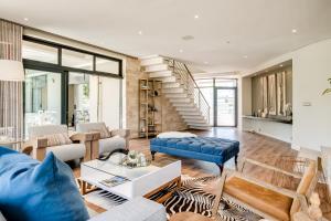 Il comprend un salon doté d'un mobilier bleu et d'un escalier. dans l'établissement Belina - Sunset Links Golf Course Villa, au Cap