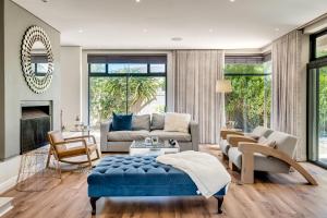 un salon avec un canapé et un pouf bleu dans l'établissement Belina - Sunset Links Golf Course Villa, au Cap 96 autres photos
