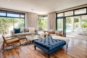 un salon avec un canapé et un pouf bleu dans l'établissement Belina - Sunset Links Golf Course Villa, au Cap