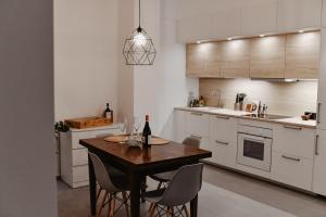 a kitchen with a table and chairs with a bottle of wine at Suite Grottabeach a due passi dal mare in Grottammare