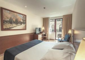 a hotel room with a bed and a television at Hotel RH Sorolla Centro in Valencia