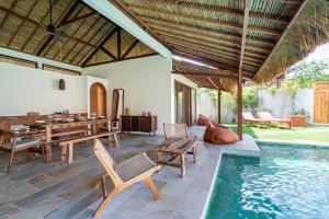 einen Essbereich im Freien mit einem Tisch und einem Pool in der Unterkunft Villa Krilu - Spacious private 2-bedroom & pool in Gili Air
