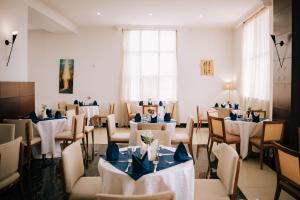 a dining room with tables and chairs with blue napkins at Tolip Olympia Hotel in Addis Ababa