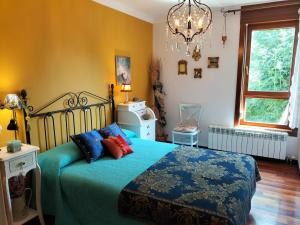 Schlafzimmer mit einem Bett mit blauen und roten Kissen in der Unterkunft Casa Boutique I Nestares I 6 pax I calm and comfort in Reinosa