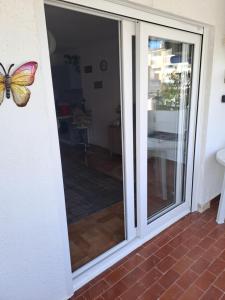 una porta scorrevole in vetro con una farfalla sopra di Los Dorados a Peñíscola