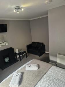 a bedroom with a bed and a black couch at cellardyke en-suite rooms in Cellardyke