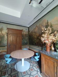 a dining room with a table and blue chairs at Domaine Clairfontaine Noyarey - Suites Junior in Noyarey