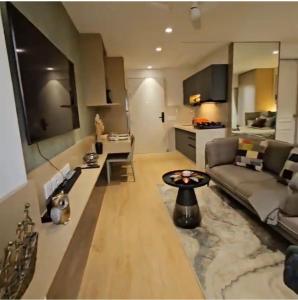 浦那Urban Nest - Viman Nagar- 1 km from Airport的带沙发和桌子的客厅