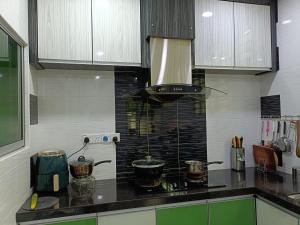 a kitchen with a stove with two pots on it at 主人房玻璃市港口 in Kuala Perlis