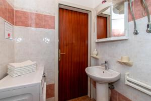 a bathroom with a red door and a sink at House Nicol Fazana in Fažana