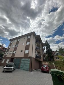 a building with two cars parked in front of it at studio apartman elegant in Vrnjci