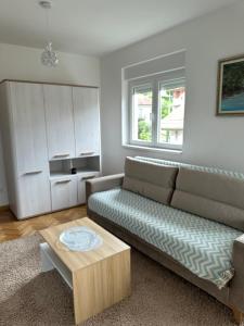 a living room with a couch and a coffee table at studio apartman elegant in Vrnjci