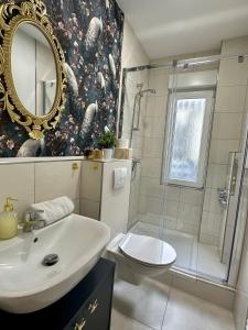 ein Badezimmer mit Waschbecken, Toilette und Spiegel in der Unterkunft Premium-Apartment im Duisburger Süden, nähe Düsseldorf Flughafen & Messe, Komplett ausgestattetes Apartment mit modernen Altbau-Flair in Duisburg