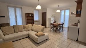 Una sala de estar con un sofá y una cocina con una mesa. en Condo-Micio Luna, en Azzano