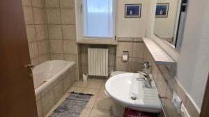 Un baño con lavabo, bañera e inodoro. en Condo-Micio Luna, en Azzano