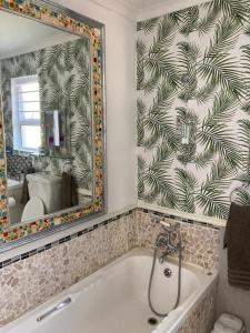 a bathroom with a large mirror and a tub at Constantia Lazy River in Cape Town