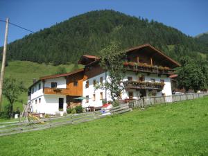 a large white building with a mountain in the background at Haus Salvenmoser in Walchsee