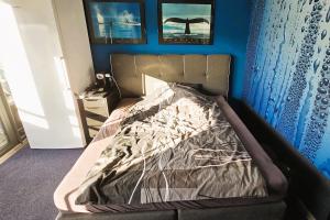 een bed in een slaapkamer met een blauwe muur bij Let's RelaxX 60QM Free parking in Mülheim an der Ruhr