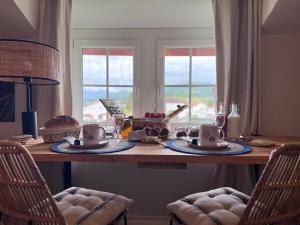 a table with food and cups on top of it at Maison Biscaya , La chambre 2e étage in Caro