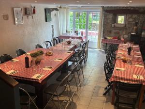 a row of tables in a restaurant with red table runners at Le Coq en Pâte in La Roque-Esclapon