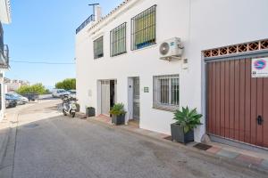 a white building with a motorcycle parked on a street at El Rincón de Dorcica Ruiz in Frigiliana
