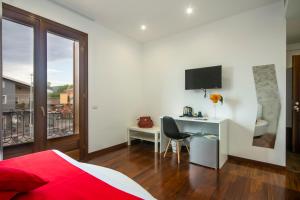 una camera da letto con un letto e una scrivania con una televisione di Mareneve Resort a Linguaglossa