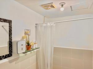 y baño con cortina de ducha y espejo. en Attractive studio with Luxury bed Good for 1-4pax High speed WiFi with Netflix Free Pool & Parking, en Suba