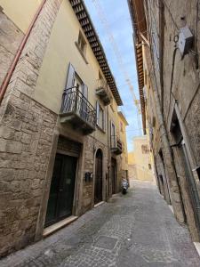 an empty alley in an old building with a balcony at Nel cuore di Ascoli -casa vacanze in Ascoli Piceno