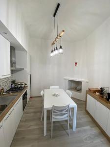 a white kitchen with a white table and chairs at Nel cuore di Ascoli -casa vacanze in Ascoli Piceno
