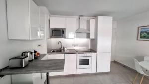 a kitchen with white cabinets and a counter top at Beautiful 43m2 with two double beds everything nearby in Nice +3 photos