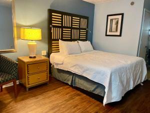 a bedroom with a bed and a lamp on a night stand at Motel M Lewisburg in Lewisburg