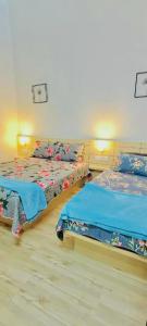 a bedroom with two beds with blue sheets at Homestay DEEDORA in Seri Manjung