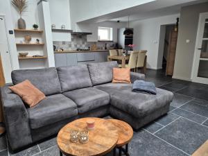 a living room with a couch and a table at Gastenverblijf Oesj in Eijsden