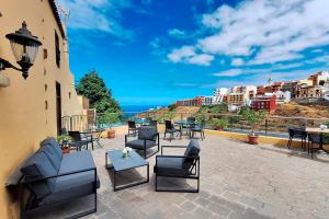 a patio with chairs and tables and a view of the city at Hotel Rural Bentor in Los Realejos