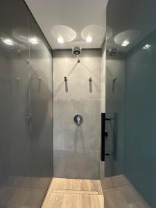 eine Dusche mit Glastür im Badezimmer in der Unterkunft Bless Hospedagem - Flat 117 premium beira mar de cabo branco in João Pessoa