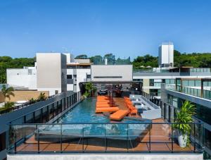 ein Balkon mit Pool auf einem Gebäude in der Unterkunft Bless Hospedagem - Flat 117 premium beira mar de cabo branco in João Pessoa