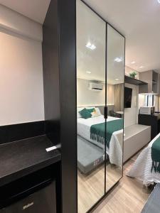 ein Zimmer mit einem Schlafzimmer mit einem Bett und einem Spiegel in der Unterkunft Bless Hospedagem - Flat 117 premium beira mar de cabo branco in João Pessoa + 34 Fotos