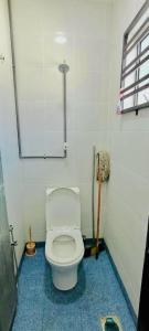 a bathroom with a white toilet in a room at Homestay DEEDORA in Seri Manjung
