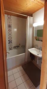 a bathroom with a sink and a tub and a toilet and a sink at Narcisse 15 in Champoussin