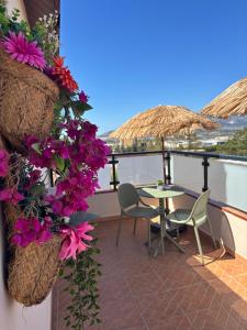 un balcone con tavolo, sedie e fiori di La Posada RR junto al Aeropuerto de Málaga a Málaga