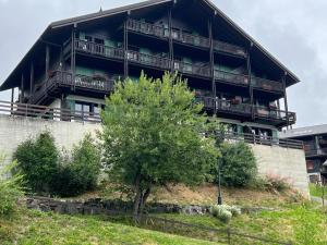 a building with a tree in front of it at Narcisse 15 in Champoussin