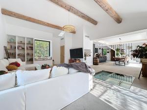 un soggiorno con un divano bianco e una TV di La villa dans les arbres - Triangle d'or du Luberon a Ménerbes