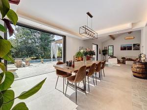 una sala da pranzo con tavolo e sedie in legno di La villa dans les arbres - Triangle d'or du Luberon a Ménerbes