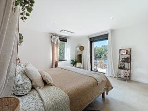 una camera da letto con un letto e una grande finestra di La villa dans les arbres - Triangle d'or du Luberon a Ménerbes Altre 37 foto